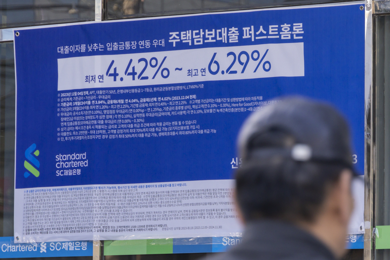 서울 한 시중은행 영업점의 대출 안내문 앞을 시민이 지나가고 있다.[연합]