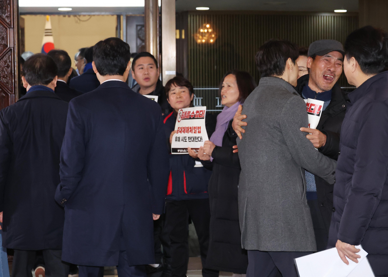 1일 국회에서 열린 더불어민주당 의원총회 앞에서 정의당과 노동계 관계자들이 회의장으로 향하는 의원들을 향해 중대재해처벌법 유예 반대 입장을 피력하고 있다. 더불어민주당은 이날 본회의 전 의원총회를 열고 국민의힘이 제시한 중처법 최종 협상안을 논의한다. [연합]