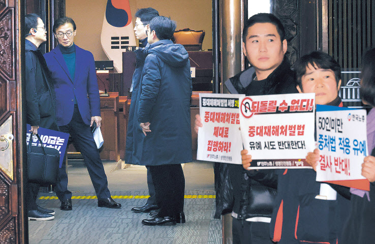 정의당과 노동계 관계자들이 지난 1일 국회에서 더불어민주당 의원총회에 입장하는 의원들을 향해 중대재해처벌법 유예 반대 시위를 하고 있다. 민주당은 이날 중대재해법의 50인 미만 사업장 적용을 2년 유예하자는 국민의힘 제안을 수용하지 않기로 했다. [연합]