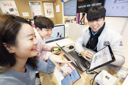 KT가 삼성전자와 함께 기존 폰을 자녀에게 물려주는 ‘갤럭시 패밀리폰 프로그램’을 시행한다. KT플라자에서 고객들이 기존폰을 물려주고 받는 서비스를 소개받고 있다. [KT 제공]