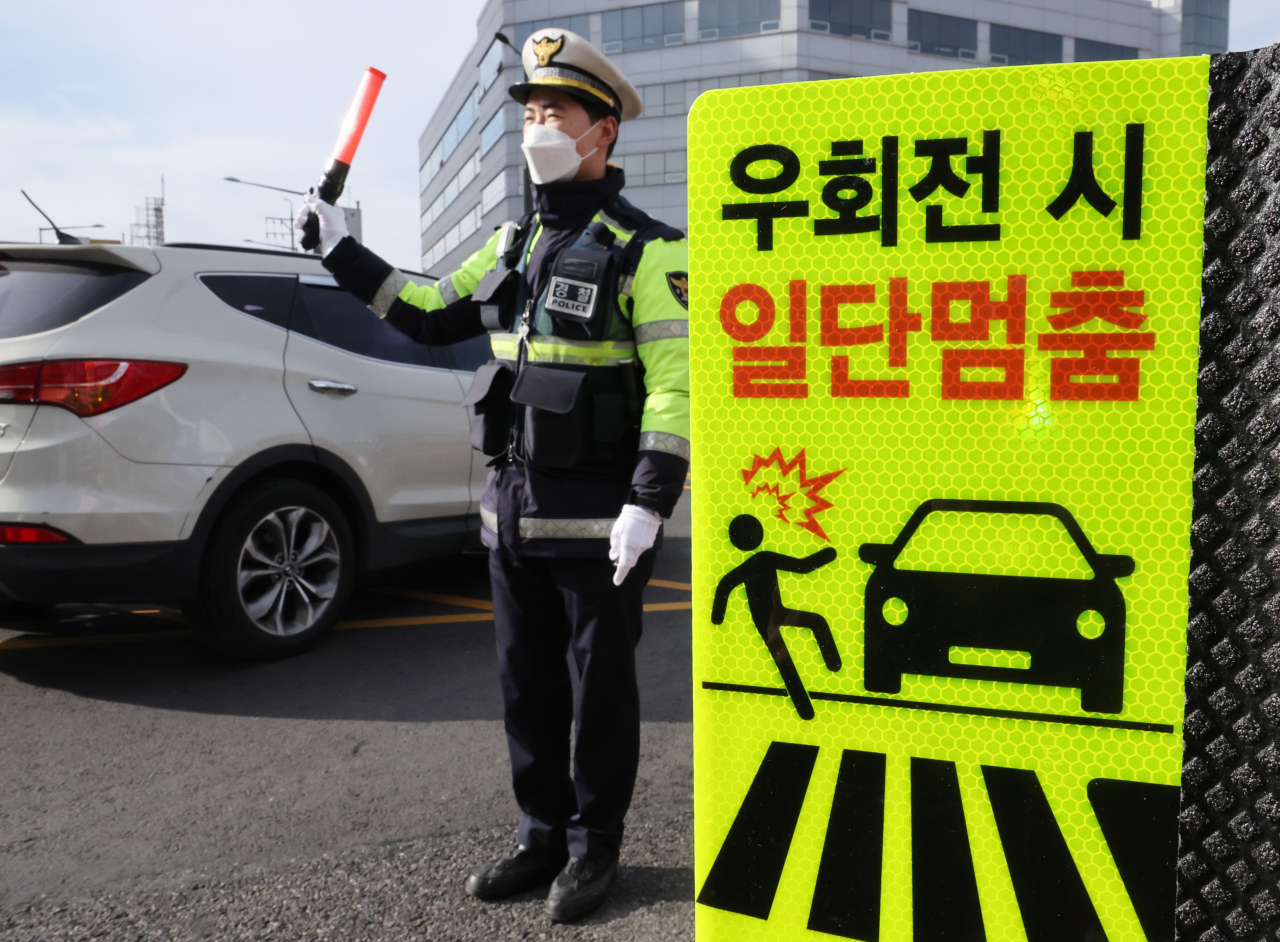 운전자가 교차로에서 우회전할 때 일시 정지해야 하는 개정 도로교통법이 시행된 1년 동안 우회전 교통사고가 약 8.4% 감소한 것으로 나타났다. 19일 서울 강서구 한 교차로에서 경찰이 우회전 일시 정지 계도 및 단속 활동을 벌이고 있다. [연합]
