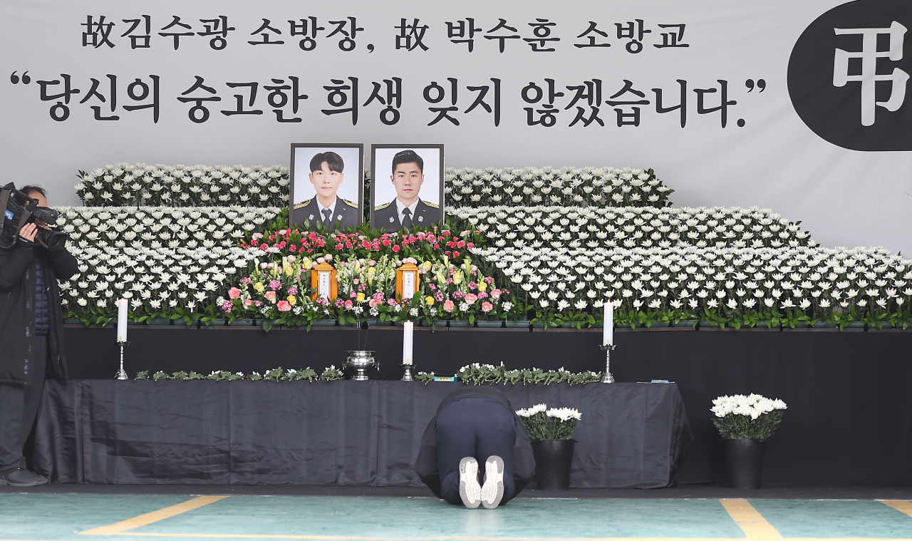 2일 경북 문경소방서에 마련된 고(故) 김수광(27) 소방장과 박수훈(35) 소방교의 분향소에서 한 시민이 절을 하고 있다. [연합]