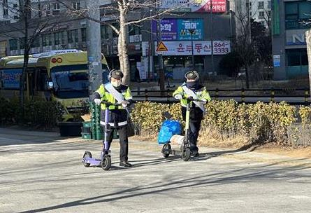 모범운전자회 서포터즈가 인하대학교 역사 주변 개인형 이동장치 기기를 정리하고 있다.