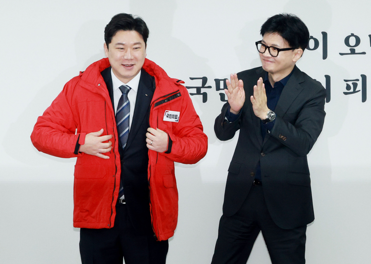 한동훈 국민의힘 비상대책위원장이 5일 오전 서울 여의도 당사에서 열린 인재영입식에게 ‘사격황제’ 진종오 대한체육회 이사에게 당 점퍼를 입혀주고 있다. [연합]