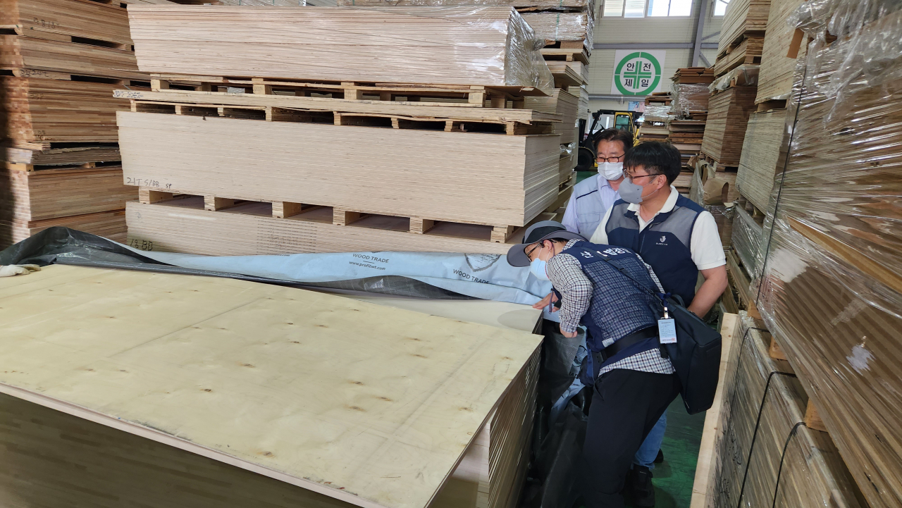 산림당국 합동단속반의 수입합판 측면 표시사항 확인 모습.