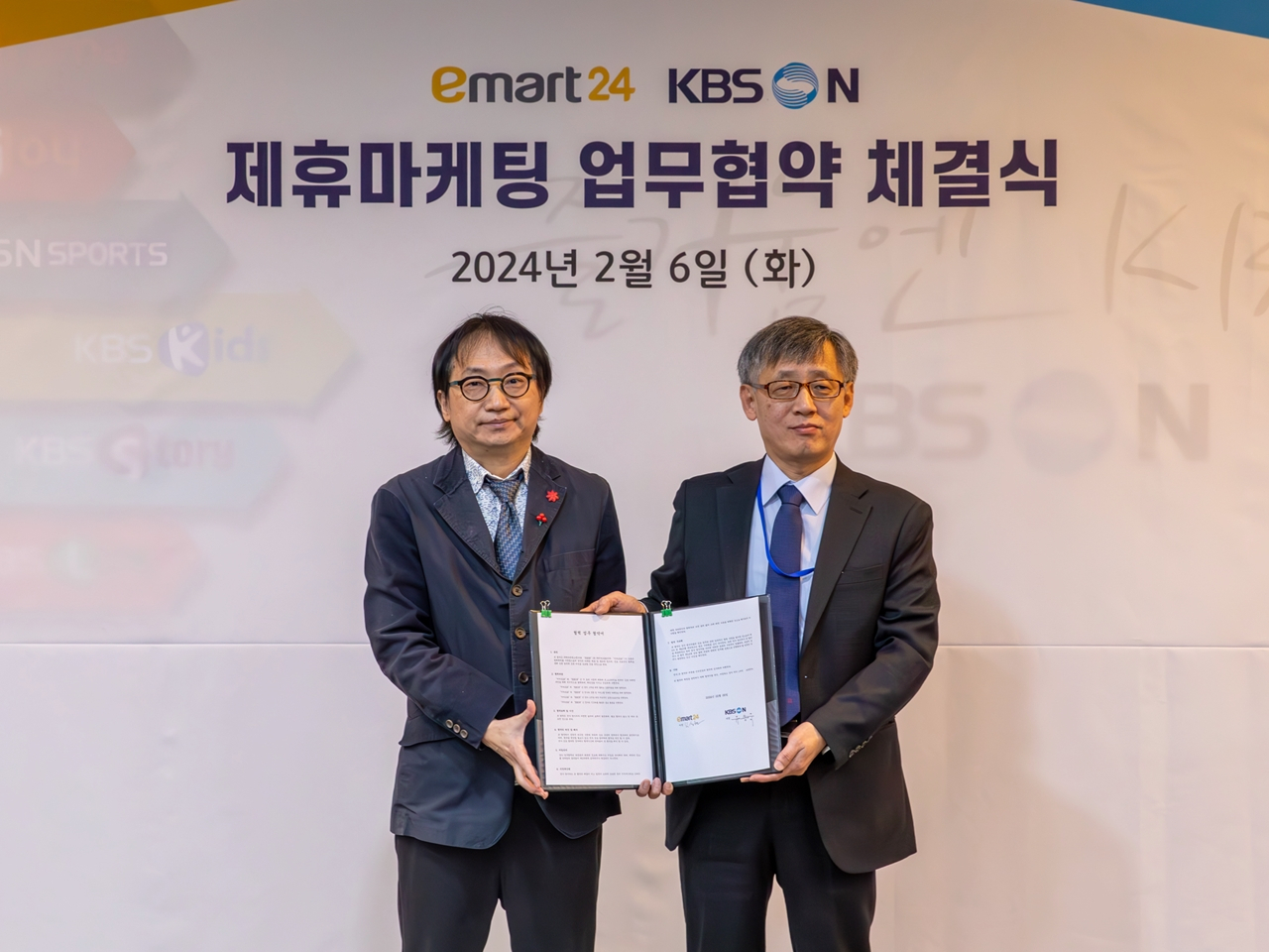 김상현(왼쪽) 이마트24 마케팅담당과 KBS N 유용욱 경영본부장이 지난 6일 KBS미디어센터에서 업무협약식 후 기념촬영을 하고 있다. [이마트24 제공]