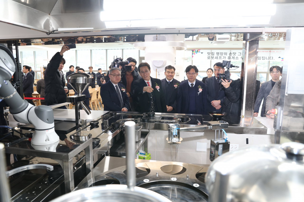 7일 영동고속도로 문막 휴게소에서 함진규 한국도로공사 사장(왼쪽 두번째)이 로봇셰프가 조리하는 모습을 보고 있다. [한국도로공사]