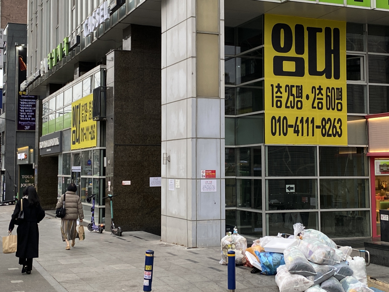 A "for lease" sign hangs in the window of a building where Lotteria's Sinchon branch once stood. (Hwang Joo-young/The Korea Herald)