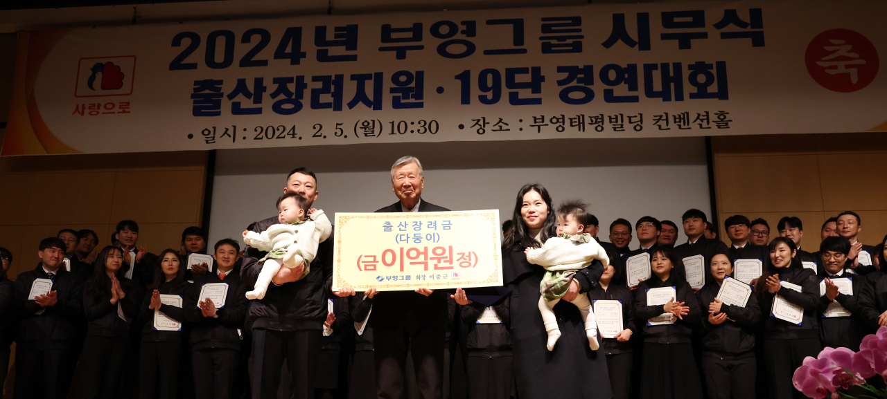 이중근 부영그룹 회장이 지난 5일 오전 서울 중구 부영빌딩에서 열린 시무식에서 직원 가족에게 출산장려금을 전달한 뒤 기념촬영을 하고 있다. [연합]