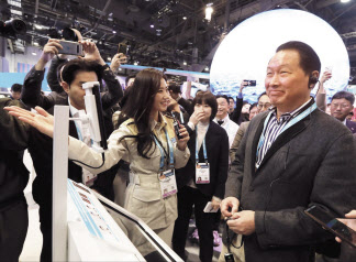 최태원 SK그룹 회장이 지난 1월 미국 라스베이거스에서 열린 세계 최대 전자 박람회 CES 2024 SK 전시관에서 ‘AI(인공지능) 포춘텔러’에 대한 설명을 듣고 있다. [SK 제공]