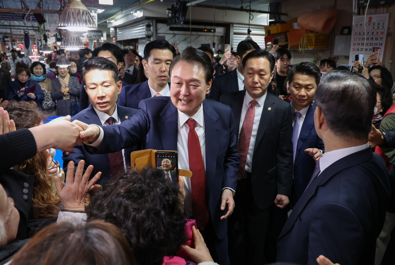 윤석열 대통령이 13일 오후 부산 동래구 동래시장을 찾아 상인과 시민들에게 인사하고 있다. [연합]