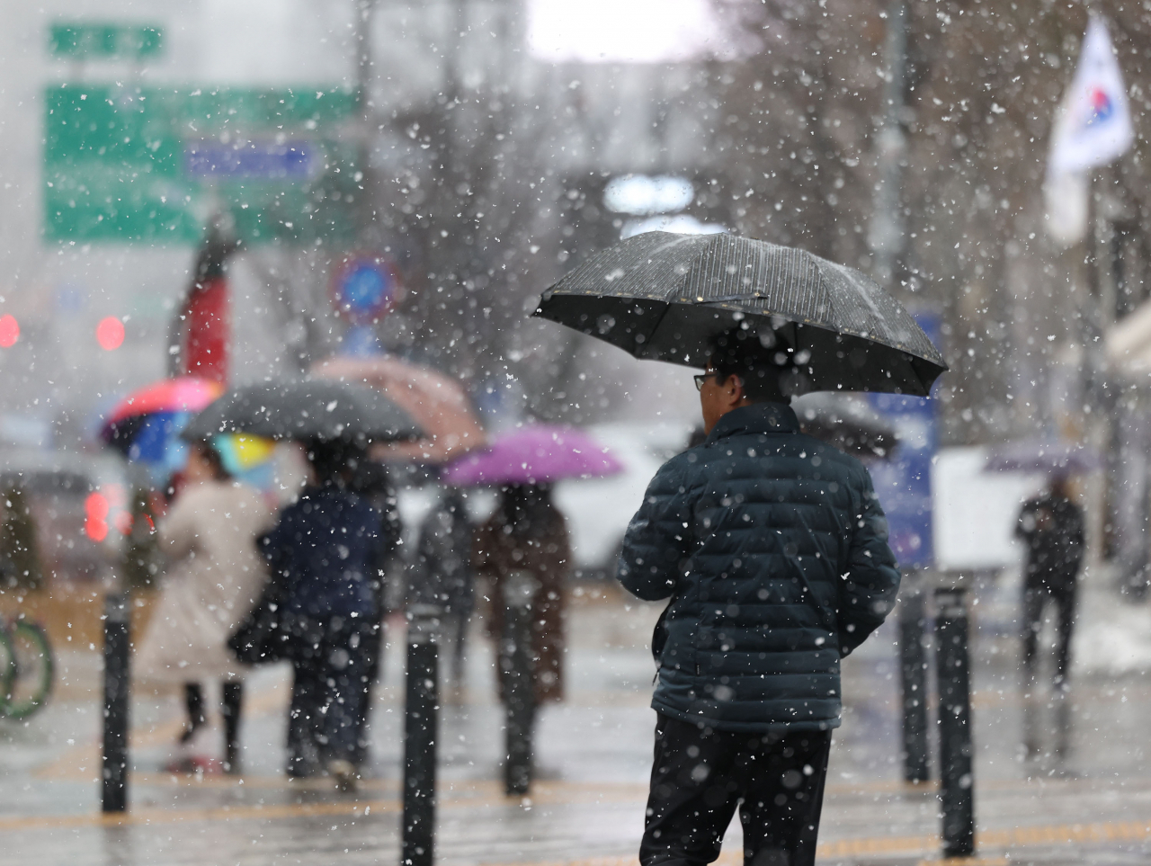 전국 대부분 지역에 비나 눈이 내린 지난 15일 오후 서울 중구 덕수궁 인근에서 시민들이 우산을 쓰고 이동하고 있다. [연합]