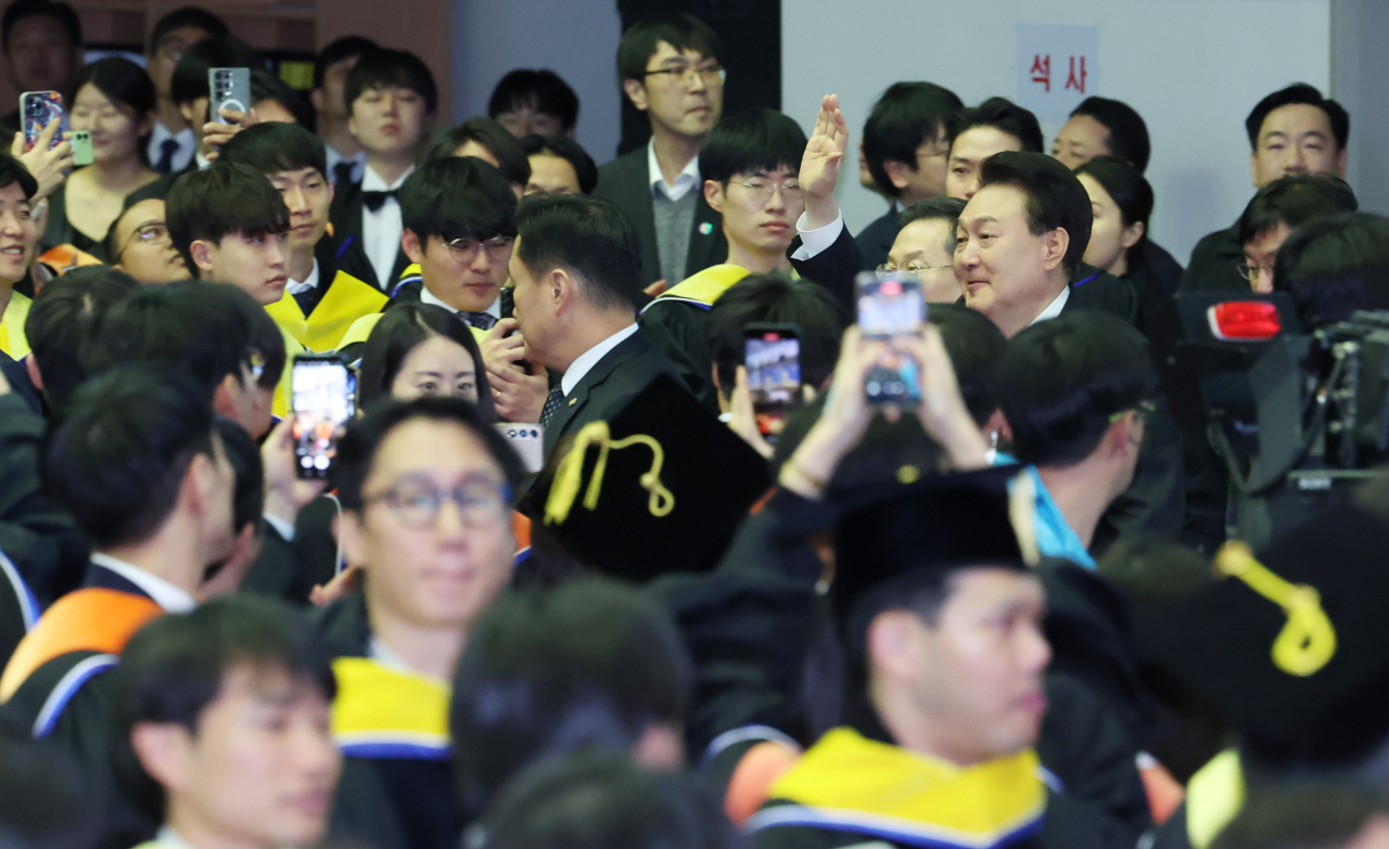 윤석열 대통령이 16일 대전 유성구 카이스트(KAIST)에서 열린 2024년 학위수여식에서 축사 뒤 졸업생들을 격려하며 행사장을 떠나고 있다. [연합]