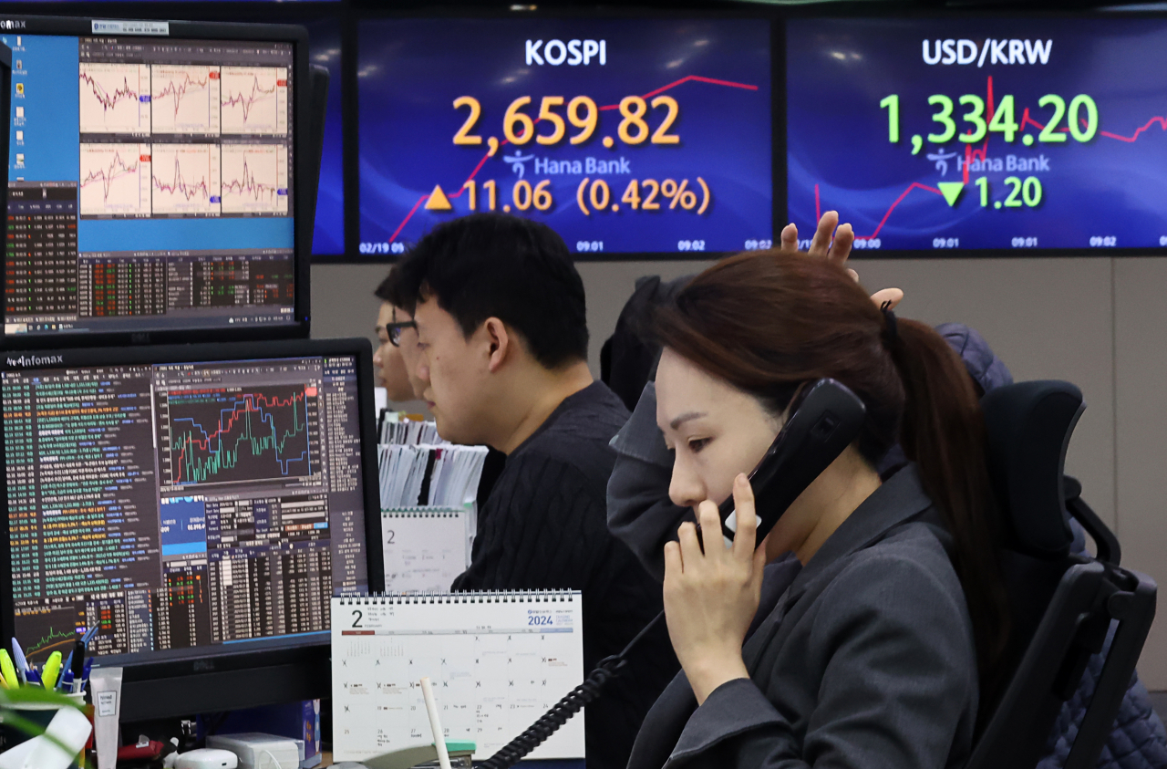 코스피가 장 초반 2660대에서 강보합세를 보이고 있는 19일 오전 서울 중구 하나은행 딜링룸에서 딜러들이 업무를 보고 있다. 연합뉴스