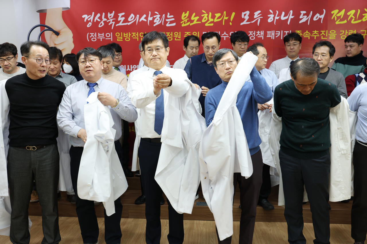 경북도의사회 이우석 회장 등 도의사회 소속 의사들이 지난 15일 오후 7시 경북도의사회관에서 정부의 의대 정원 확대 정책에 반발하는 규탄대회를 열고 의사가운 탈의식을 진행하고 있다. [연합]
