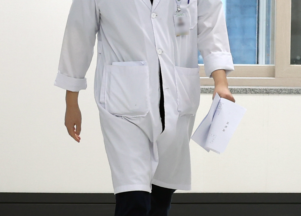 19일 오전 광주 동구 전남대학교병원 교육수련실 앞에서 한 전공의가 사직서를 들고 가고 있다. 전국 전공의들은 정부의 의대 정원 확대 방침에 반발해 집단 사직서 제출 움직임을 보이고 있다. 연합뉴스