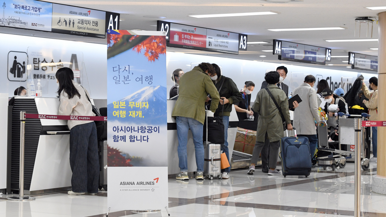 People undergo departure procedures at Gimpo Airport on Oct. 11, 2022. (Im Se-jun/The Korea Herald)
