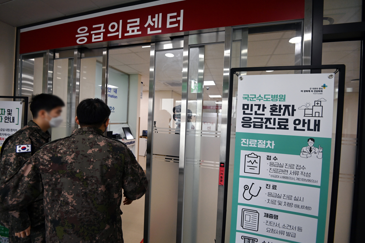 전공의들의 집단 사직으로 의료대란이 현실화된 가운데 국방부가 전국 12개 군병원 응급실을 민간인에게 개방하면서 인공호흡기 역할을 톡톡히 하고 있다. 20일 경기 성남 국군수도병원 응급실에 민간환자 응급진료 안내문이 세워져 있다. [사진공동취재단]