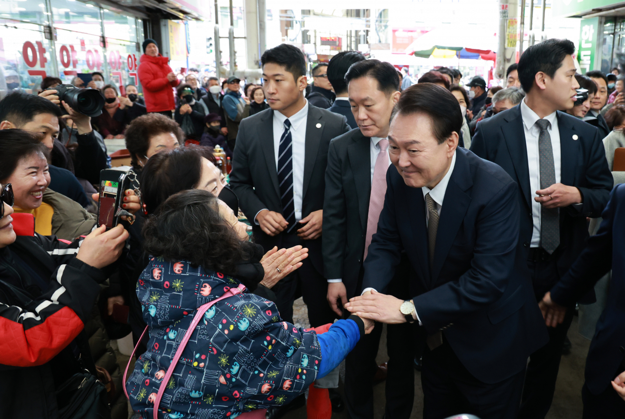 윤석열 대통령이 22일 경남 창원시 마산합포구 마산어시장을 찾아 시민들과 인사하고 있다. [연합]