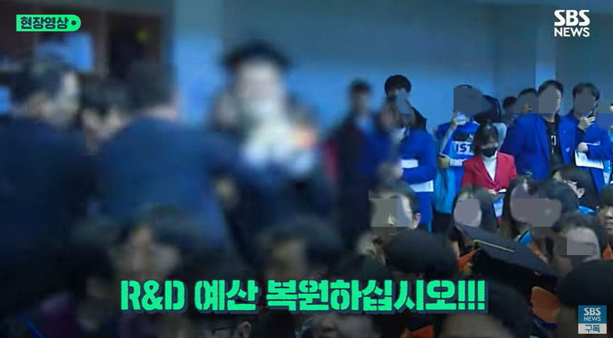 최근 대전 카이스트 학위 수여식에서 윤석열 대통령을 향해 “R&D 예산 복원하라”고 외친 한 졸업생이 경호원들에 의해 저지되는 모습. [SBS 뉴스 캡처]