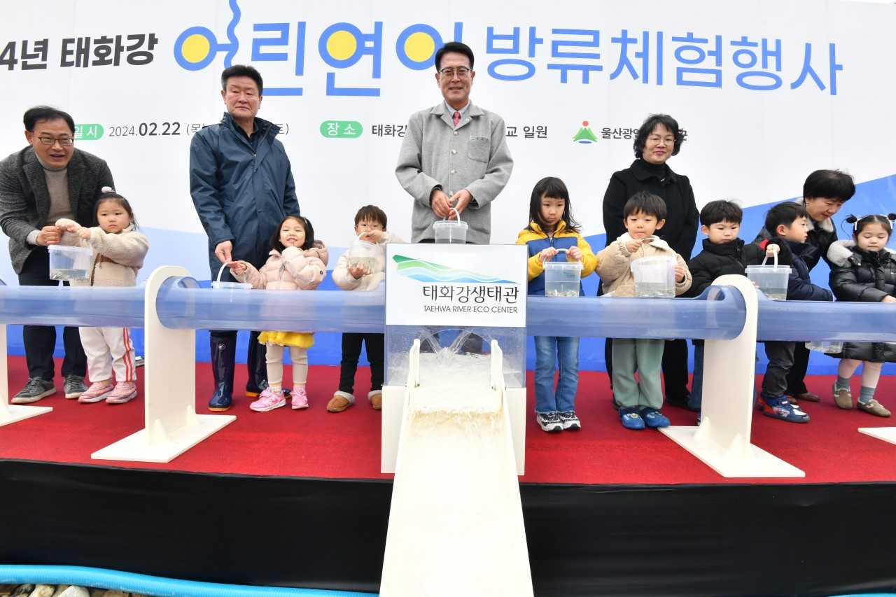 울주군 태화강생태관이 22일부터 생태관 인근 선바위교 및 구영교 일대에 어린연어 46만5천마리를 방류하는 가운데 이날 이순걸 울주군수(가운데)를 비롯한 울주군 관계자 및 인근 어린이집 어린이들이 어린연어 방류행사에 참여하고 있다. [사진=울주군]