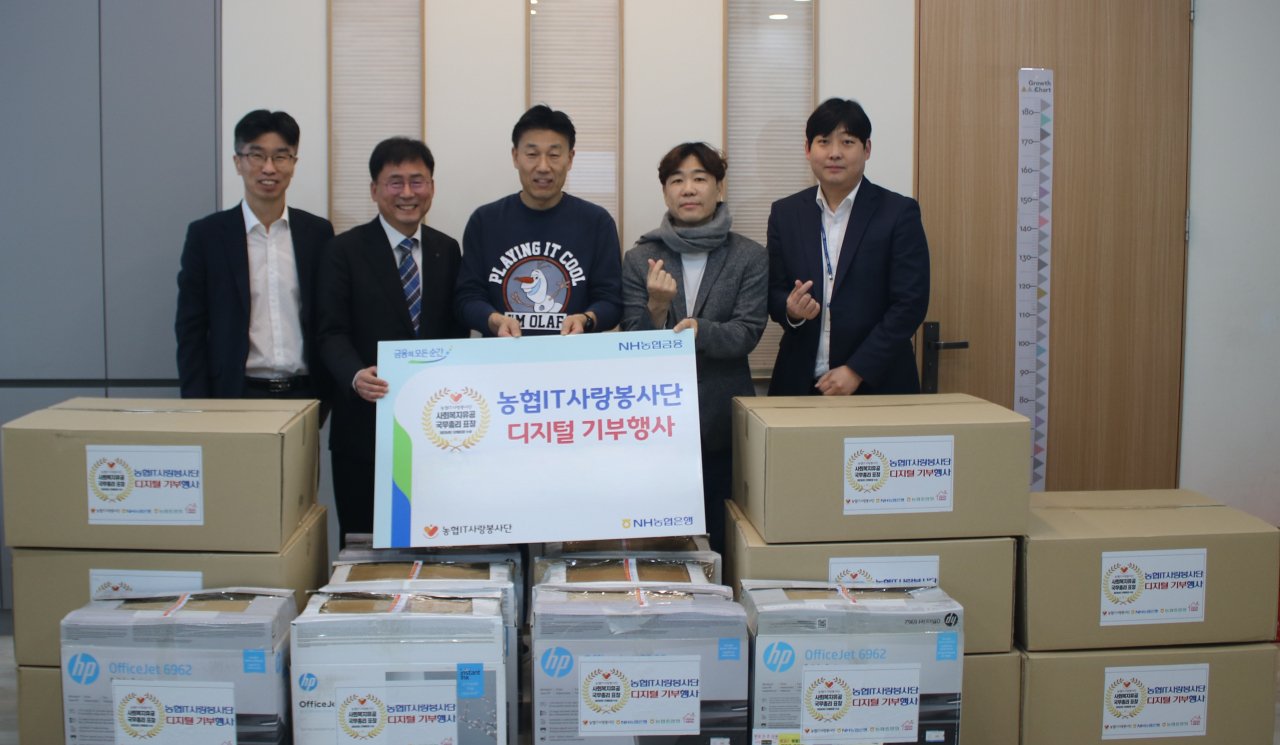 22일 서울 서초구 관내 지역 아동센터에서 개최된 디지털기기 기부행사에서 황재현(왼쪽 두 번째) NH농협은행 IT 부행장과 서을구(오른쪽 두 번째) IT사랑봉사단장, 김기철(가운데) 우면지역아동센터장이 기념 촬영을 하고 있다. [NH농협은행 제공]