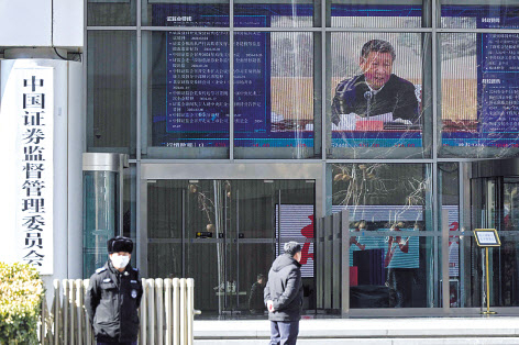 지난 8일 중국 베이징에 있는 중국증권감독관리위원회 건물 안 화면에서 시진핑 중국 국가주석이 나오는 뉴스 영상이 보여지고 있다. [AFP]