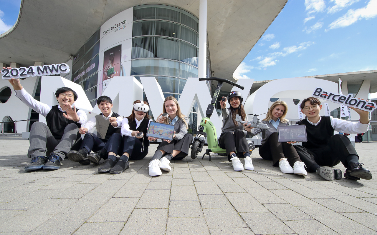 MWC24 행사장 인근에서 참가 직원들이 KT 전시 아이템을 소개하는 모습[KT 제공]
