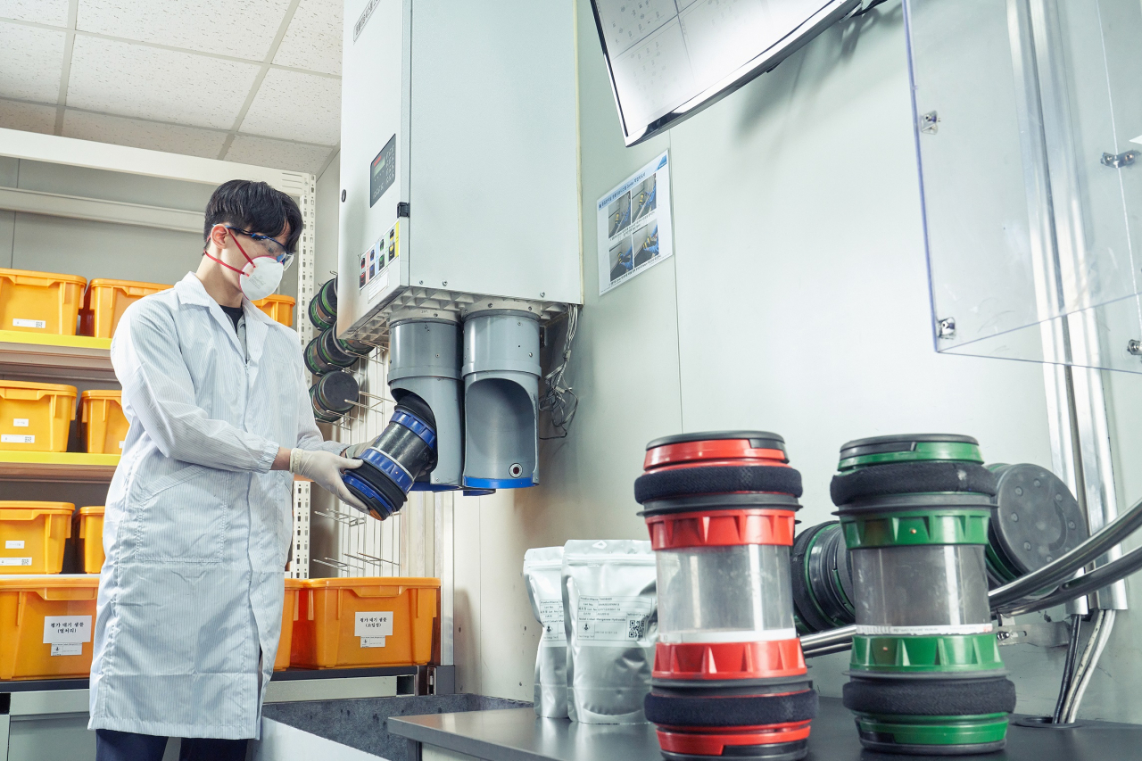 A worker puts a quality control sample into the automated transfer system at Posco Future M‘s cathode plant in Gwangyang, South Jeolla Province. (Posco Future M)
