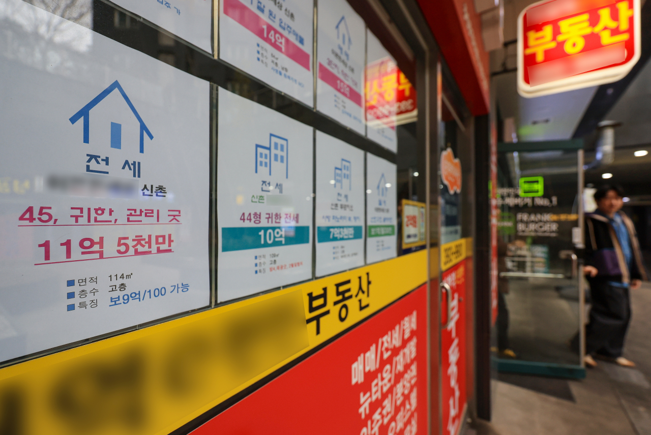 서울 한 부동산중개사무소 앞을 시민이 지나가고 있다.[연합]
