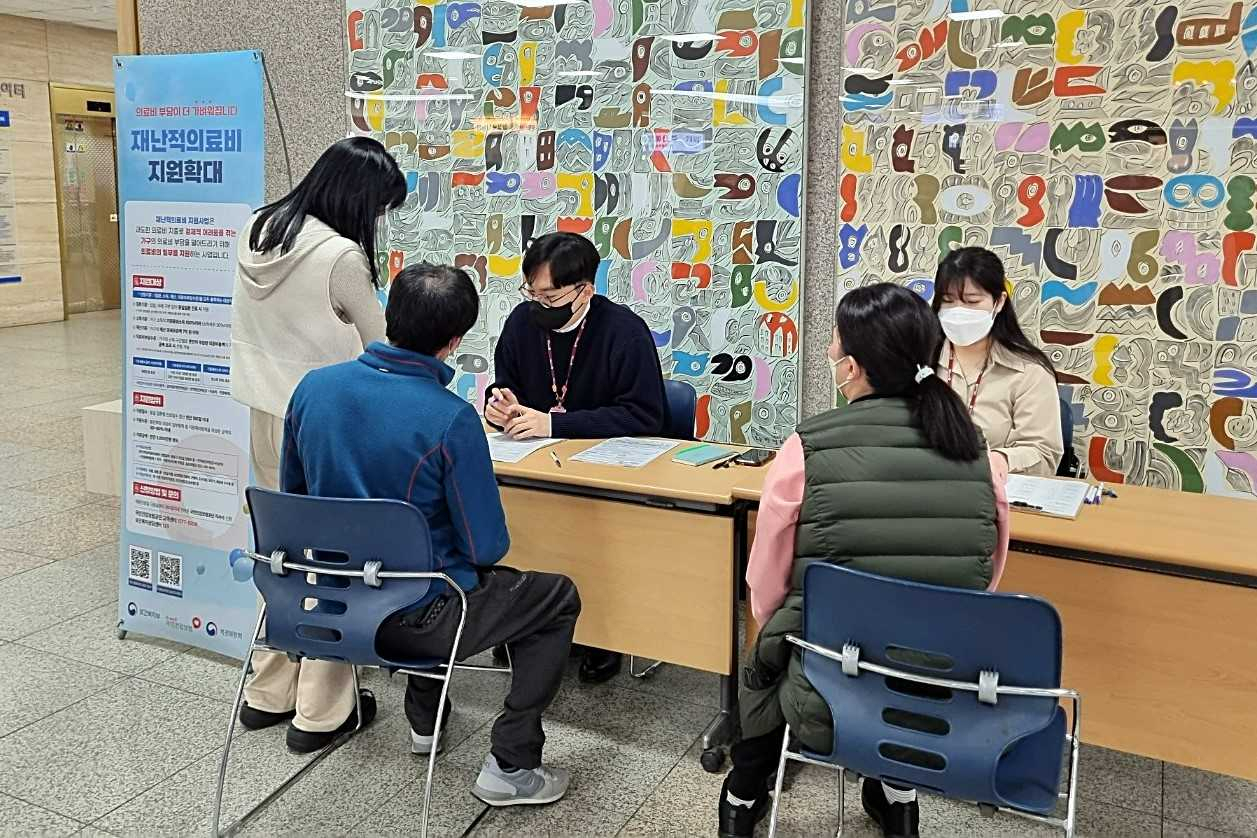 화순전남대병원과 국민건강보험공단 관계자들이 최근 병원 1층 로비에서 내원객을 대상으로 ‘재난적 의료비 지원제도’에 대해 설명하고 있다.