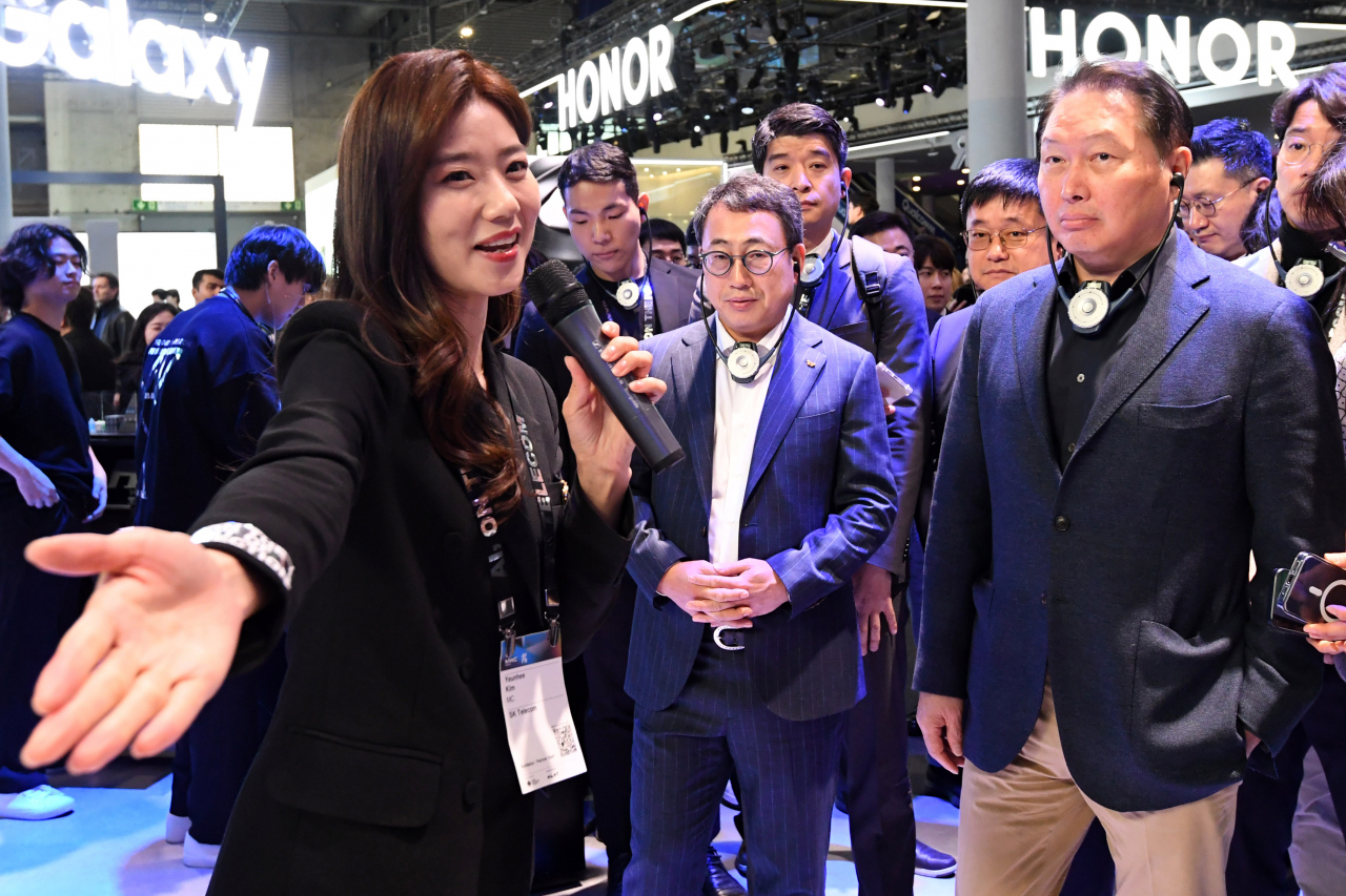 ‘모바일 월드 콩그레스(MWC) 2024’가 스페인 바르셀로나 피라 그란 비아 전시장에서 개막한 26일(현지시간) 최태원(오른쪽) SK 회장이 유영상 SK텔레콤 대표 및 관계자들과 전시장 SKT 부스를 둘러보고 있다. [연합]