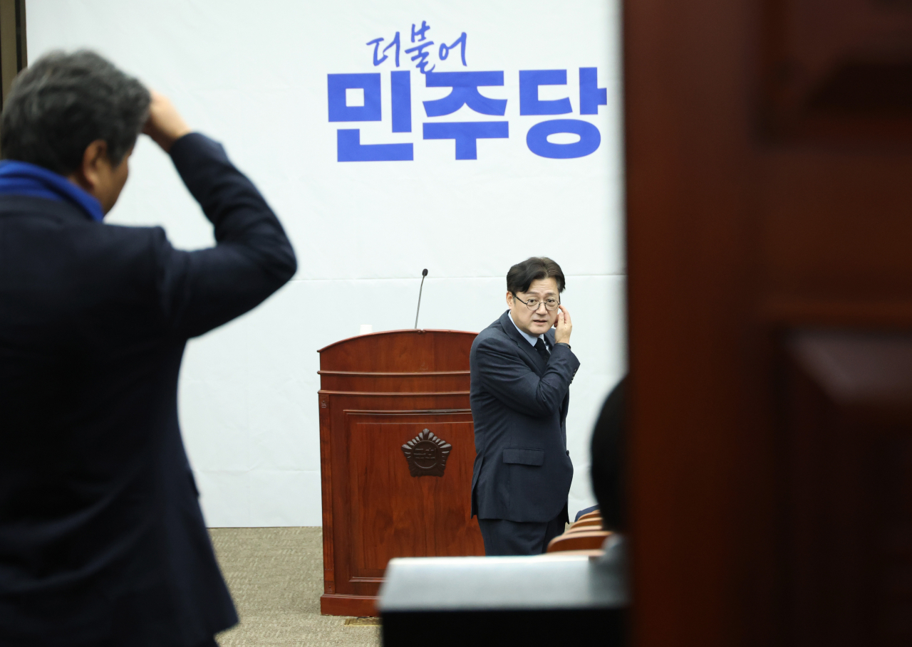 홍익표(가운데) 더불어민주당 원내대표가 지난 21일 국회에서 열린 의원총회에서 동료 의원들과 대화하는 모습. [연합]