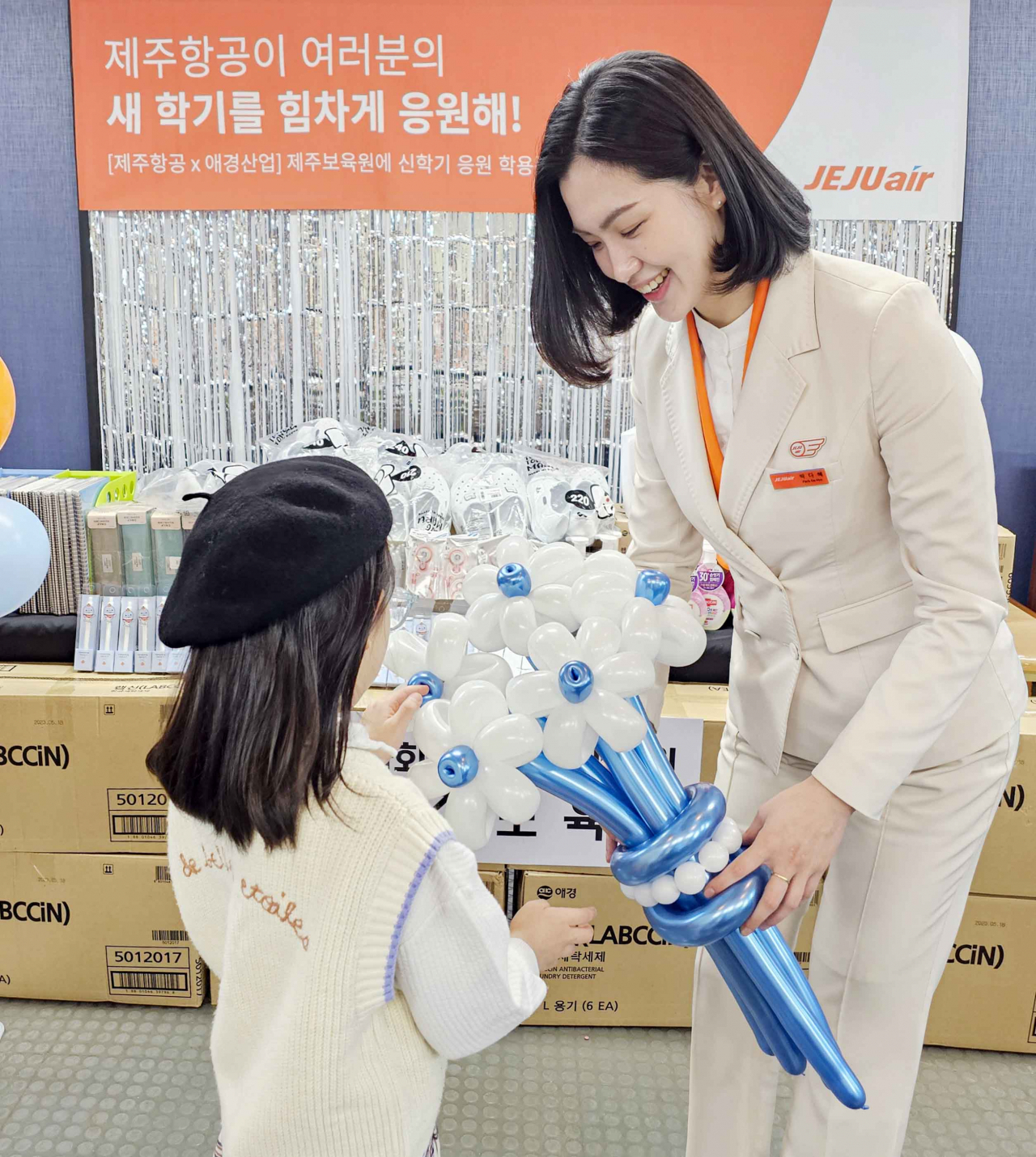 제주항공 객실승무원이 제주시에 위치한 제주보육원 학생들에게 새 학기 선물과 풍선 꽃다발을 전달하고 있다. [제주항공 제공]