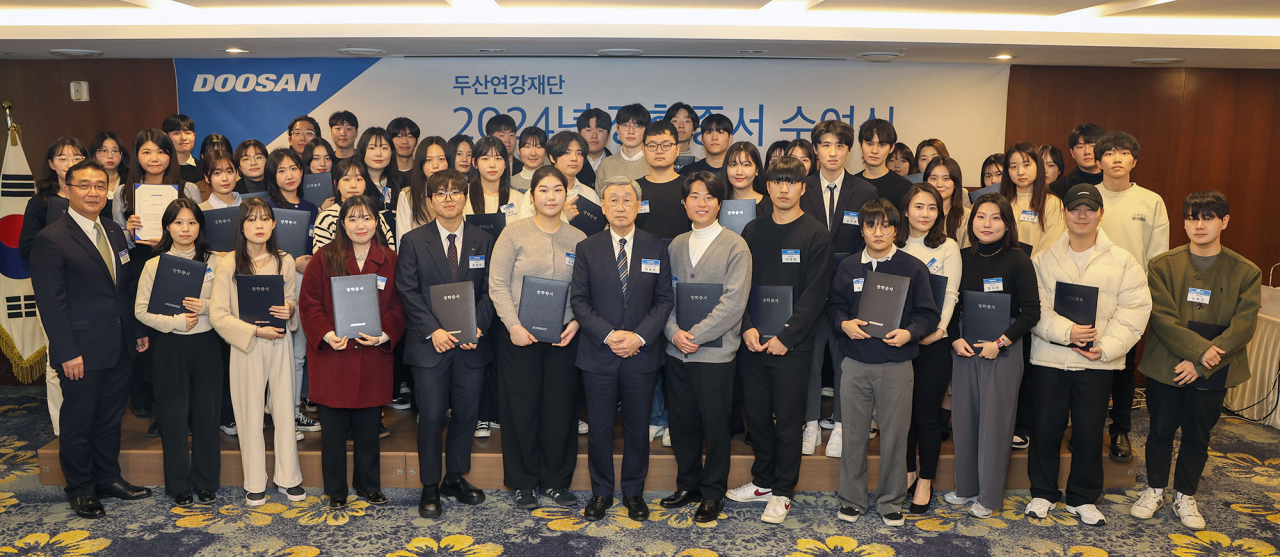 박용현(앞줄 가운데) 두산연강재단 이사장이 지난 26일 열린 장학증서 수여식에서 장학생들과 기념촬영을 하고 있다. [두산 제공]