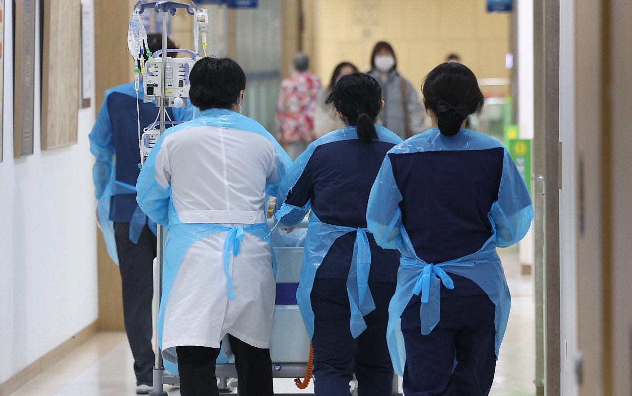 전공의 집단이탈이 장기화하는 가운데 27일 오전 대구 한 대학병원에서 의료진이 중환자를 옮기고 있다.[연합]