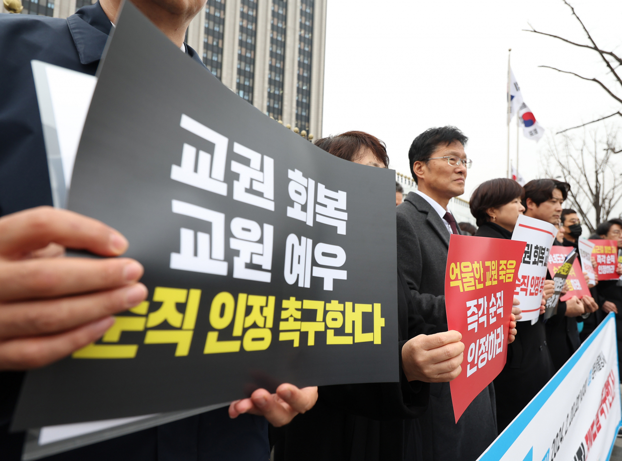 한국교원단체총연합회와 교사노동조합연맹·전국교직원노동조합 등 단체 회원들이 20일 오전 정부서울청사 앞에서 기자회견을 열고 지난해 숨진 서울 서이초 교사의 순직을 인정하고 관련 제도 개선을 촉구하는 손팻말을 들고 있다. [연합]