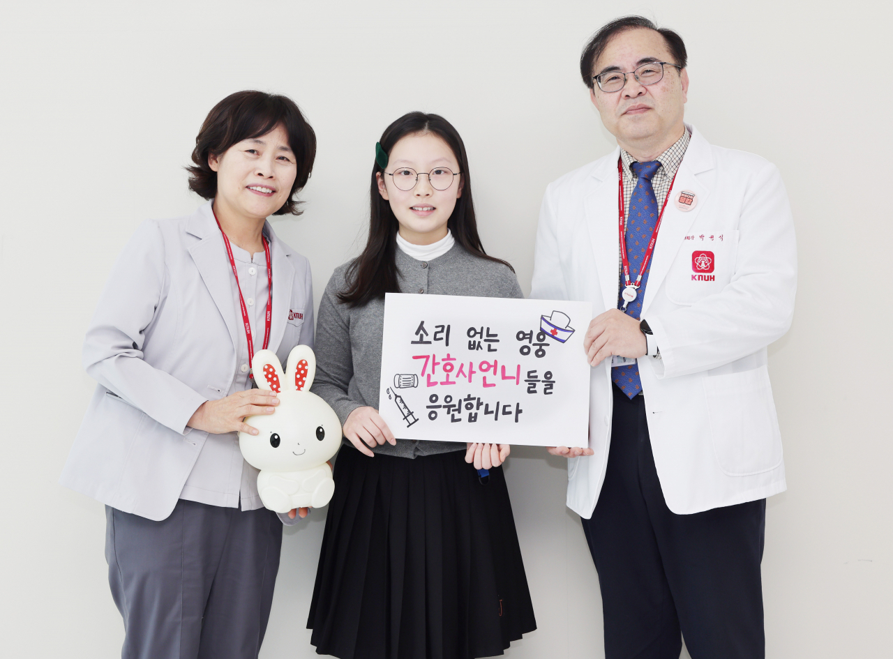 장예진 양이 간호사를 응원하는 문구와 돈을 모았던 토끼 저금통을 들고 박성식 병원장, 김미영 간호부장과 기념 촬영을 하고 있다.[칠곡군 제공]