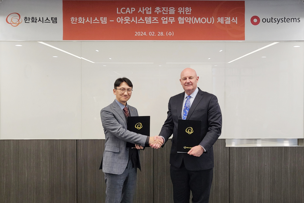 김윤수(왼쪽) 한화시스템 밸류크리에이션 사업부 기술담당 상무와 마크 위저 아웃시스템즈 아태지역 총괄대표가 지난 28일 LCAP(로우코드 애플리케이션 플랫폼) 사업 추진을 위한 업무협약(MOU)을 체결한 뒤 기념촬영을 하고 있다. [한화시스템 제공]
