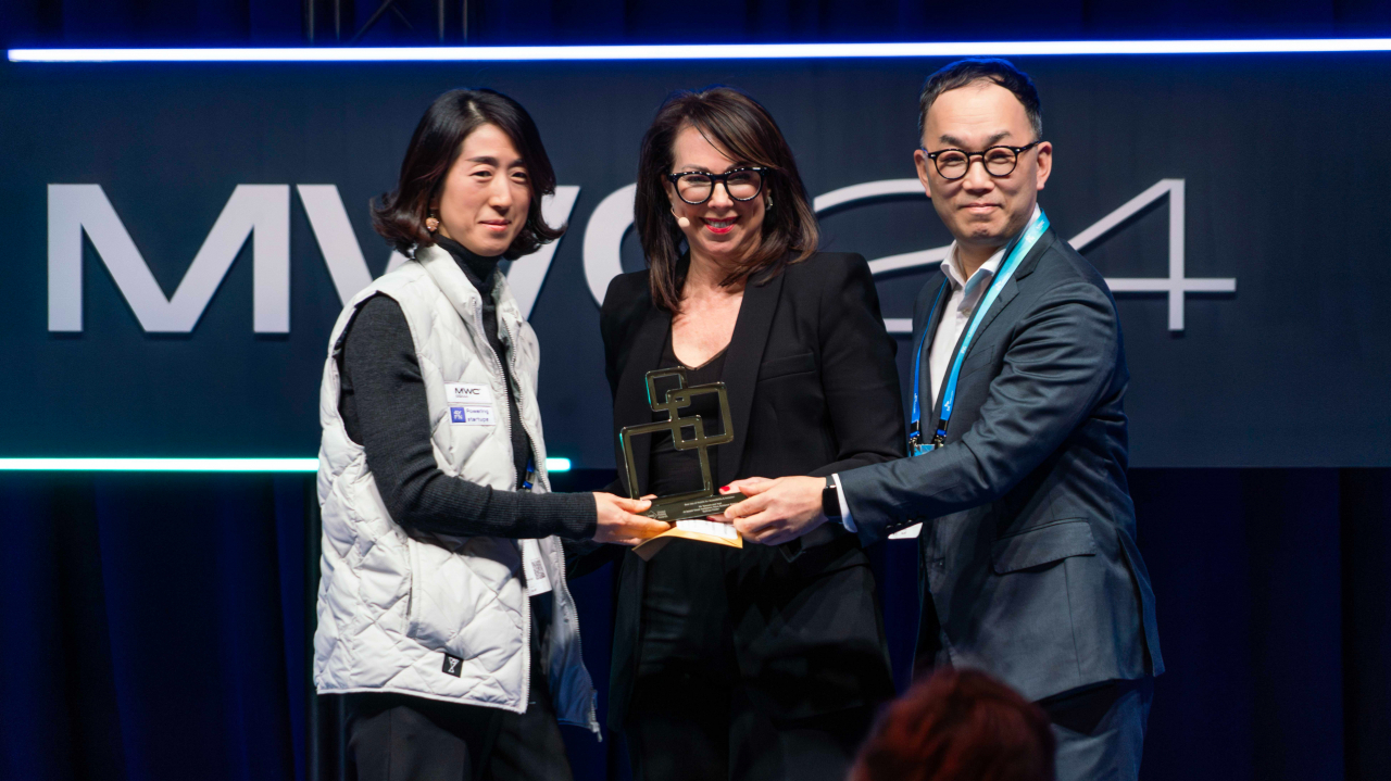 엄종환(왼쪽 세번째) SKT ESG혁신 담당과 조수원(왼쪽 첫번째) 투아트 대표가 GLOMO 2024에서 AI기반 시각보조 음성 안내 서비스 ‘설리번파인더’로 수상하고 있다. [SK텔레콤 제공]