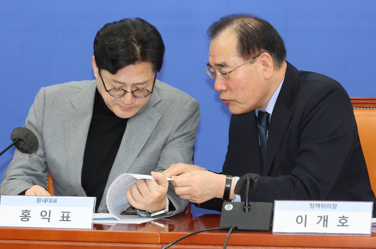 더불어민주당 홍익표 원내대표와 이개호 정책위의장이 27일 국회에서 열린 고금리 부담완화 공약 발표에서 대화하고 있다.[연합]