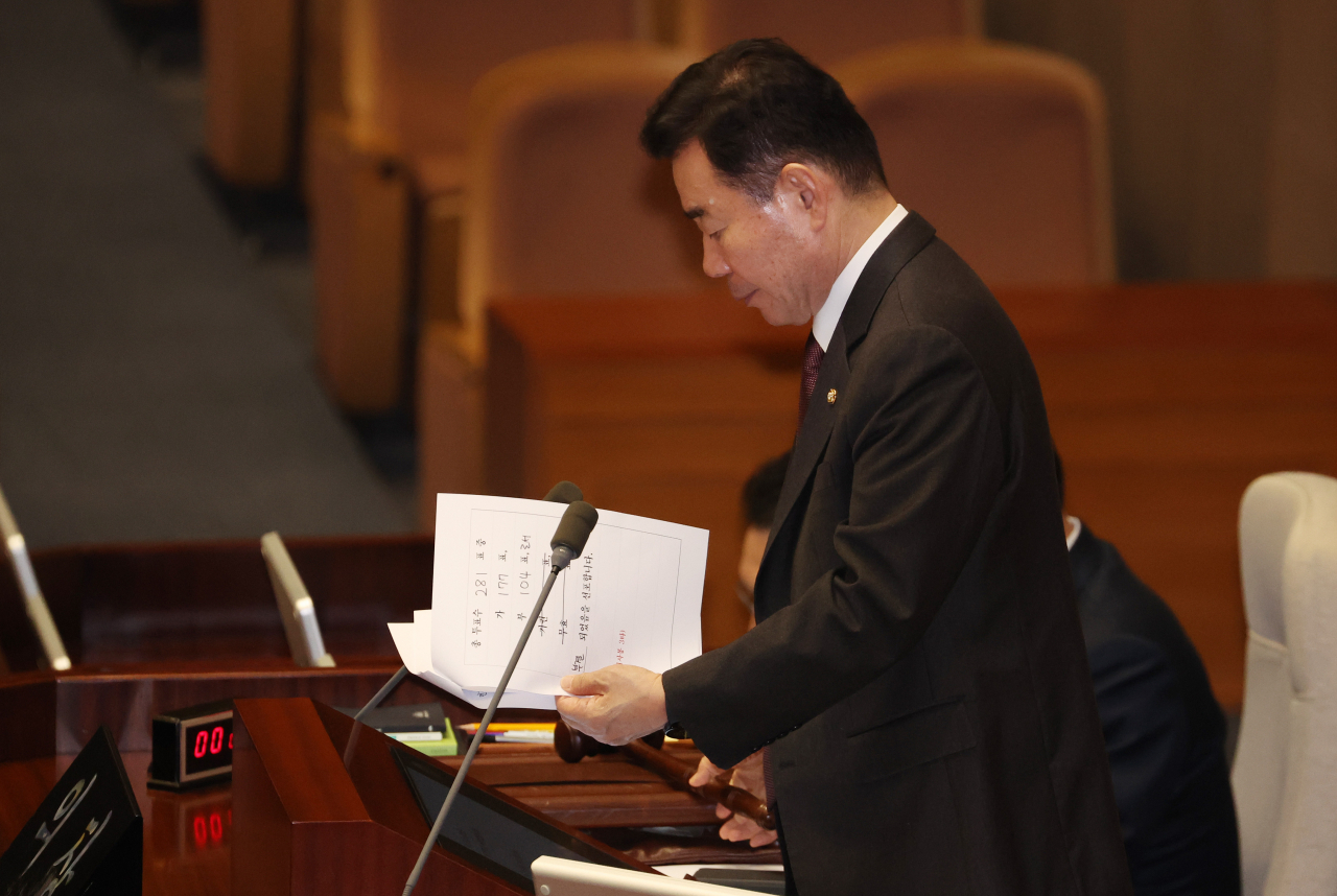 29일 국회에서 열린 본회의에서 김진표 국회의장이 '쌍특검법' 재표결 결과가 표시된 종이를 들고 있다. [연합]