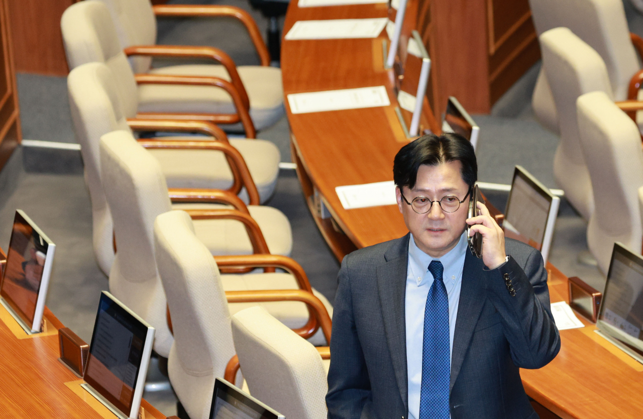 더불어민주당 홍익표 원내대표가 29일 저녁 국회에서 열린 본회의에서 '쌍특검법' 개표 결과를 기다리며 통화하고 있다. [연합]