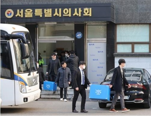 경찰이 의료법 위반 등 혐의로 고발당한 대한의사협회 관계자들에 대해 강제 수사에 착수한 가운데 1일 서울 영등포구 서울시의사회에서 압수수색을 마친 경찰이 압수품을 옮기고 있다.[연합]