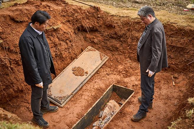 A scene from “Exhuma,” starring Yoo Hae-jin (left) and Choi Min-sik (Showbox)