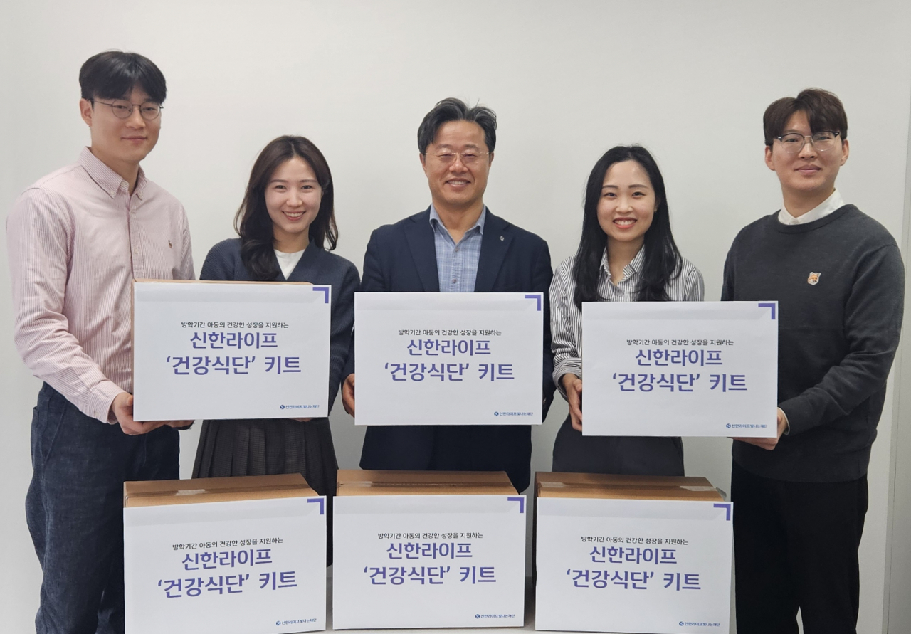 신한라이프빛나는재단 김순기 사무국장(가운데)과 신한라이프 임직원들이 결식 우려 아동에게 전달할 건강식단 키트와 함께 서있다.