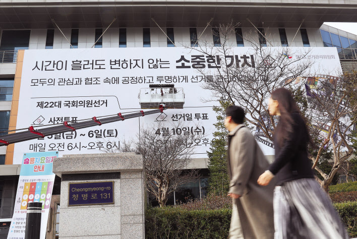 4월 10일 치러지는 제22대 국회의원선거를 앞두고 지난달 27일 경기도 수원시 경기도선거관리위원회에서 관계자들이 청사 외벽에 투표 참여 홍보 현수막을 설치하고 있다. [연합]