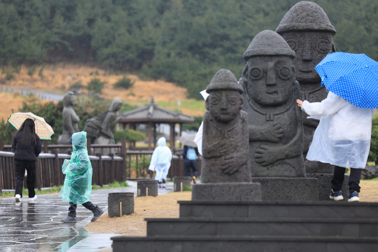지난달 29일 오전 제주 서귀포시 대정읍 송악산에 비가 내리는 가운데 관광객이 우중 산책을 하고 있다. [연합]