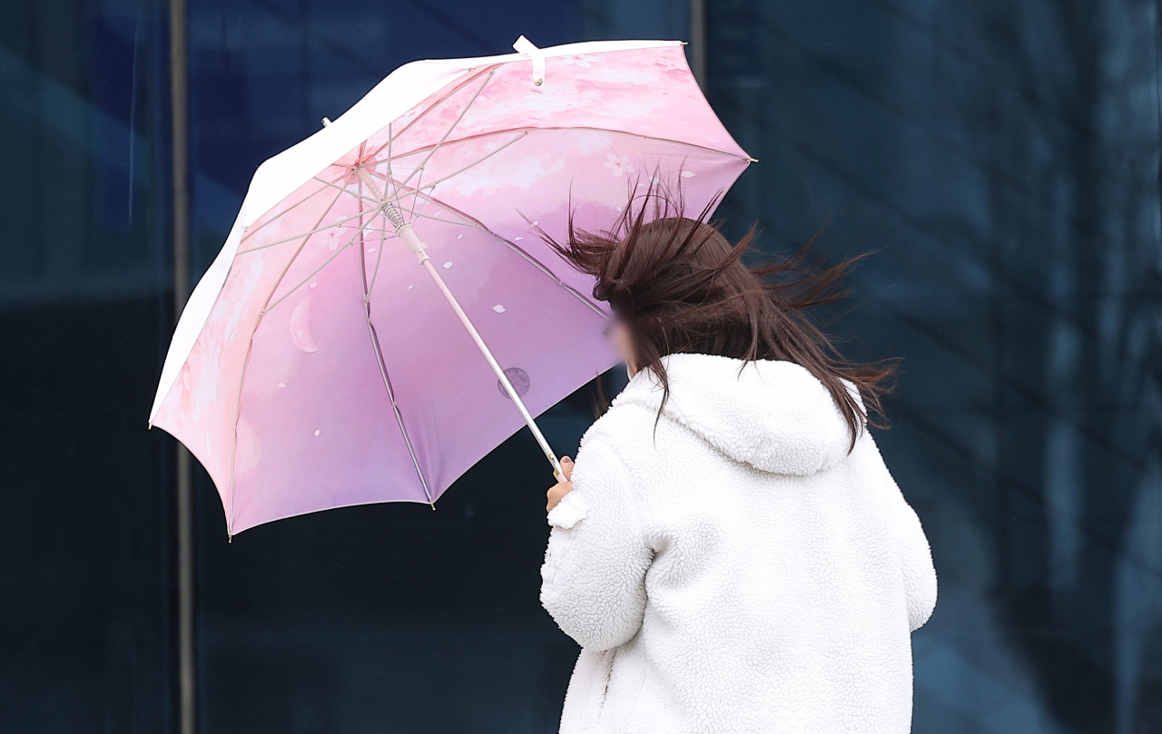 절기상 경칩인 5일 대구 한 대학 캠퍼스에서 한 시민이 우산을 쓰고 이동하고 있다. [연합]