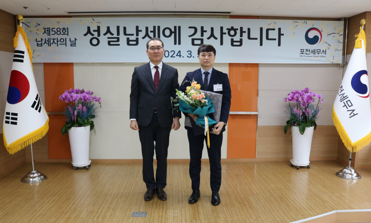 지난 5일 포천세무서 대강당에서 열린 ‘제 58회 납세자의 날’ 기념식에서 풀무원샘물 심규복(오른쪽) 재무 담당이 포천세무서 고병재 서장과 기념촬영을 하고 있다. [풀무원샘물 제공]